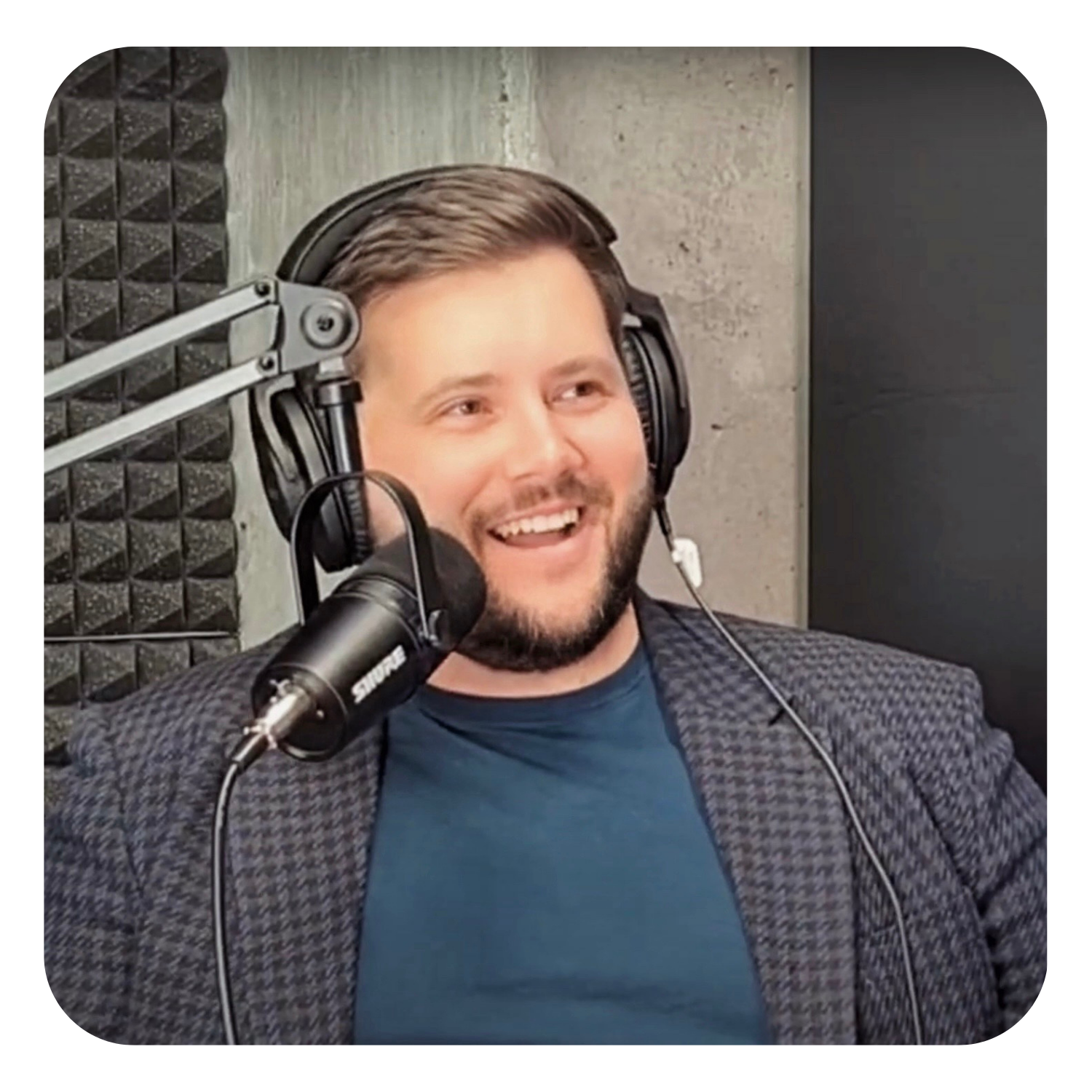 Podcast recording — host wearing headphones at a microphone in a recording studio