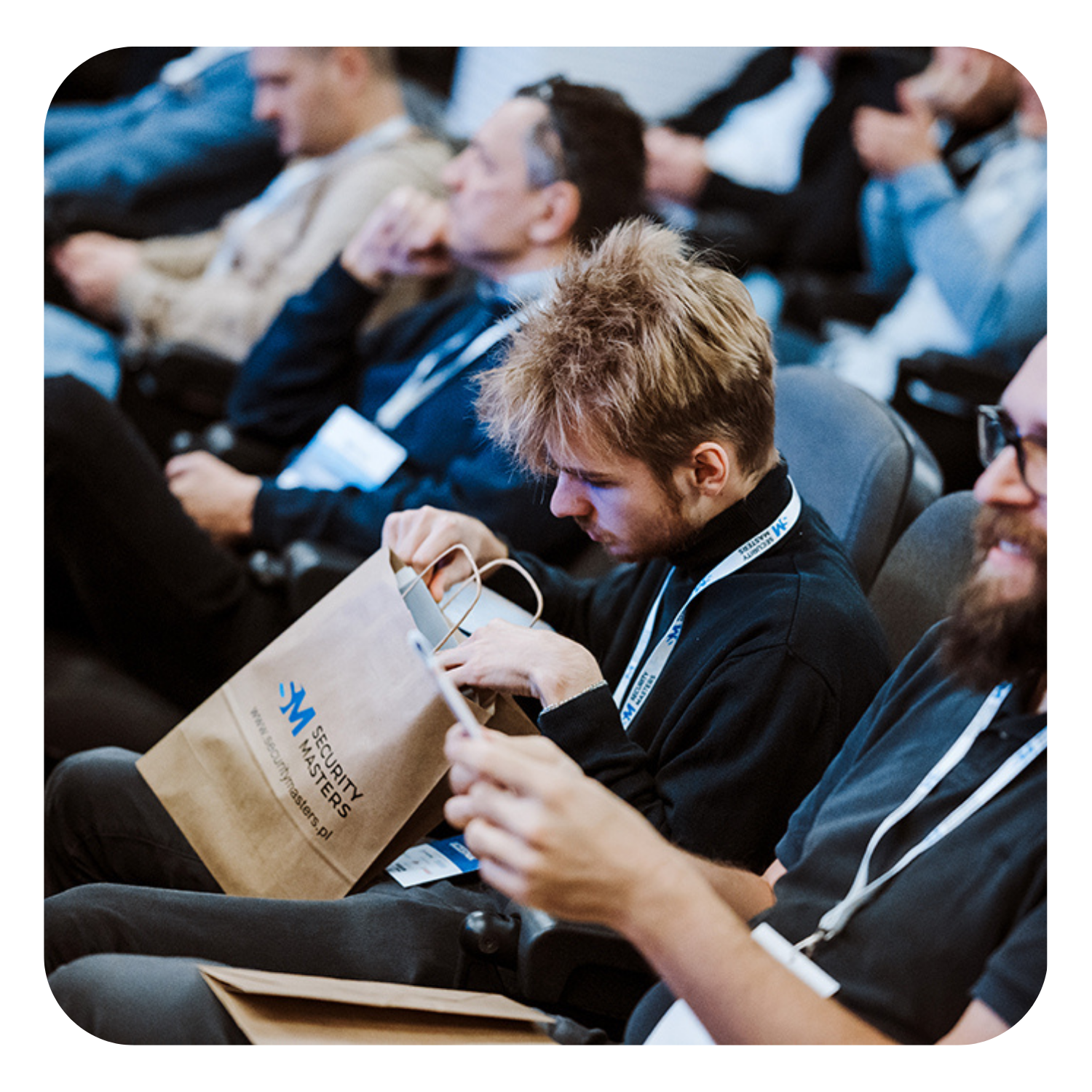 Uczestnicy konferencji — słuchacz przegląda materiały w torbie Security Masters